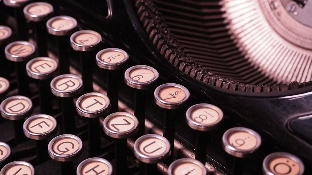 Close up of vintage typewriter keys with a sheet of paper
